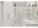 Bright bathroom with built-in shelving, bathtub, shower, marble countertop, and white hexagonal tile floor at 165 N High St, Denver, CO 80218