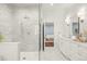 Bright bathroom with dual sinks, stone countertops, decorative mirrors, and a large glass shower with marble and tile at 165 N High St, Denver, CO 80218