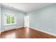 Bedroom features hardwood floors, wallpaper, a bright window with a view, and access to another room at 165 N High St, Denver, CO 80218