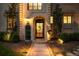 Charming entrance with an arched doorway, decorative door, and manicured landscaping illuminated by soft lighting at 165 N High St, Denver, CO 80218