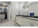 Bright main bathroom with double sinks, white cabinets, tiled floor, and a walk in closet at 20 Wilcox St # 208, Castle Rock, CO 80104