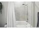 This tile shower and tub combination includes a shower curtain and modern tile surround at 20 Wilcox St # 208, Castle Rock, CO 80104