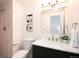 Bathroom featuring a marble countertop, dark vanity, and tiled shower at 8422 Everett Way # D, Arvada, CO 80005
