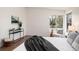 Sunlit bedroom featuring a large window, hardwood floors, and neutral-toned decor at 8422 Everett Way # D, Arvada, CO 80005