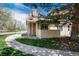 Charming exterior of home with stone chimney and beautiful landscaping at 8422 Everett Way # D, Arvada, CO 80005