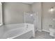 Bathroom featuring a tub with white tile surround and a glass enclosed shower at 9008 W 101St Ave, Broomfield, CO 80021