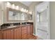Main bathroom featuring double sinks, wood cabinets, granite countertop, and soaking tub at 9008 W 101St Ave, Broomfield, CO 80021