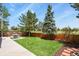 Landscaped backyard featuring a concrete patio, picnic table, a well-manicured lawn, and a wooden fence at 4664 S Union St, Morrison, CO 80465