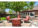 Backyard featuring a fire pit surrounded by patio and lush green landscaping at 4664 S Union St, Morrison, CO 80465