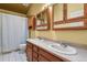 Bathroom featuring double sinks, wood cabinets, a neutral countertop, and a shower with a curtain at 4664 S Union St, Morrison, CO 80465