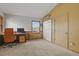 This bedroom features carpeted floors, a window with blinds, a closet, and an office desk at 4664 S Union St, Morrison, CO 80465