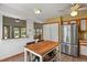 Bright kitchen with stainless steel refrigerator, light cabinets, and an island with wood countertop at 4664 S Union St, Morrison, CO 80465