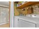 Practical laundry room with washer, dryer, shelves, and a shower in the background at 4664 S Union St, Morrison, CO 80465