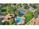 Aerial view of community pool, clubhouse, tennis court, and surrounding lush greenery at 12593 E Pacific Cir # E, Aurora, CO 80014