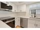 Well-lit kitchen featuring white cabinetry, stainless steel appliances, and subway tile backsplash at 12593 E Pacific Cir # E, Aurora, CO 80014