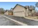 Side exterior of home featuring a large garage, paved driveway, and well-maintained landscaping at 9742 E Hawaii Pl, Aurora, CO 80247