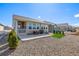A serene backyard featuring a patio with furniture, grill, and a landscaped area with gravel and artificial turf at 15979 Xanthia Way, Thornton, CO 80602