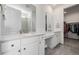 Bright bathroom featuring double vanity with white cabinets and a view into the walk-in closet at 15979 Xanthia Way, Thornton, CO 80602