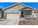 Charming home featuring stone accents, neutral siding, a cozy front porch, and a well-maintained lawn at 15979 Xanthia Way, Thornton, CO 80602