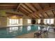 Bright indoor pool area featuring vaulted ceilings, ample natural light, and comfortable lounge seating at 15979 Xanthia Way, Thornton, CO 80602