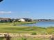 Scenic lake view with lush greenery, golf course, and neighboring homes at 15979 Xanthia Way, Thornton, CO 80602