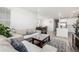 Open-concept living room that flows into the dining area and features stylish furniture and great natural light at 15979 Xanthia Way, Thornton, CO 80602