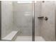 Modern tiled shower with a built-in bench and sleek fixtures at 15979 Xanthia Way, Thornton, CO 80602