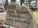 Rock signage for the 1000 South Monaco Parkway HOA at 1050 S. Monaco Pkwy, set in a grassy, tree-lined neighborhood at 1050 S Monaco Pkwy # 42, Denver, CO 80224