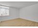 Simple bedroom with light hardwood floors and large window at 3369 S Monaco Street Pkwy # A, Denver, CO 80222