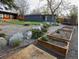 Backyard featuring raised garden beds, a detached garage, and a lush green lawn at 9380 W 51St Ave, Arvada, CO 80002