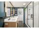 Modern bathroom with double vanity, stylish lighting, and a glass-enclosed shower at 9380 W 51St Ave, Arvada, CO 80002