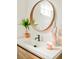 Stylish bathroom featuring a modern sink, round mirror, and decorative statue at 9380 W 51St Ave, Arvada, CO 80002