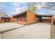 Charming single-story home with a modern wood facade, covered porch with colorful chairs, and a convenient carport at 9380 W 51St Ave, Arvada, CO 80002