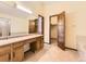 Bathroom featuring a double sink vanity, mirror and a door opening to a walk-in closet at 3210 S Espana Cir, Aurora, CO 80013