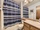 Traditional bathroom with a shower/tub combination and a blue striped curtain at 3210 S Espana Cir, Aurora, CO 80013