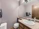 Cozy bathroom featuring a toilet, sink, and vanity, and a large mirror at 3210 S Espana Cir, Aurora, CO 80013