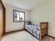Simple bedroom with a wood bed frame, neutral carpet, and a window with a wooded view at 3210 S Espana Cir, Aurora, CO 80013