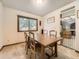 Cozy dining room with a wooden table, four chairs, and a window providing natural light at 3210 S Espana Cir, Aurora, CO 80013