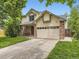 Traditional home with a brick and siding exterior, featuring a two-car garage and a well-kept front yard at 3210 S Espana Cir, Aurora, CO 80013
