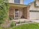 Inviting front porch with brick accents, potted plants, and bench seating near the front door at 3210 S Espana Cir, Aurora, CO 80013