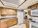 Well-lit kitchen with modern appliances, wooden cabinets, and a bright white refrigerator at 3210 S Espana Cir, Aurora, CO 80013