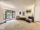 Bright living room featuring a bay window, neutral carpet, and comfortable seating arrangements at 3210 S Espana Cir, Aurora, CO 80013