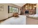 Cozy living room with a brick fireplace, wood paneling, and a large window offering a pleasant view at 3210 S Espana Cir, Aurora, CO 80013