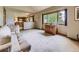 Bright living room featuring a large window, neutral carpet, and open access to the adjacent kitchen at 3210 S Espana Cir, Aurora, CO 80013