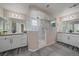 Bright bathroom features a glass shower, tile floor, double vanity, and neutral paint at 27185 E Costilla Dr, Aurora, CO 80016