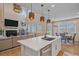 Bright open-concept kitchen with quartz counters, modern appliances, and stylish pendant lighting at 27185 E Costilla Dr, Aurora, CO 80016