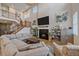 Bright and airy living room featuring a fireplace and an open floor plan with a staircase leading to the upper level at 27185 E Costilla Dr, Aurora, CO 80016