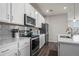 Modern kitchen with white cabinets, stainless steel appliances, and granite countertops at 13734 Ash Cir, Brighton, CO 80602