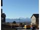 Street view of homes with mountain views and a DHL delivery truck at 13734 Ash Cir, Brighton, CO 80602