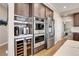 Modern kitchen features double ovens, wine cooler, and coffee bar at 5965 Topaz Vista Pl, Castle Pines, CO 80108